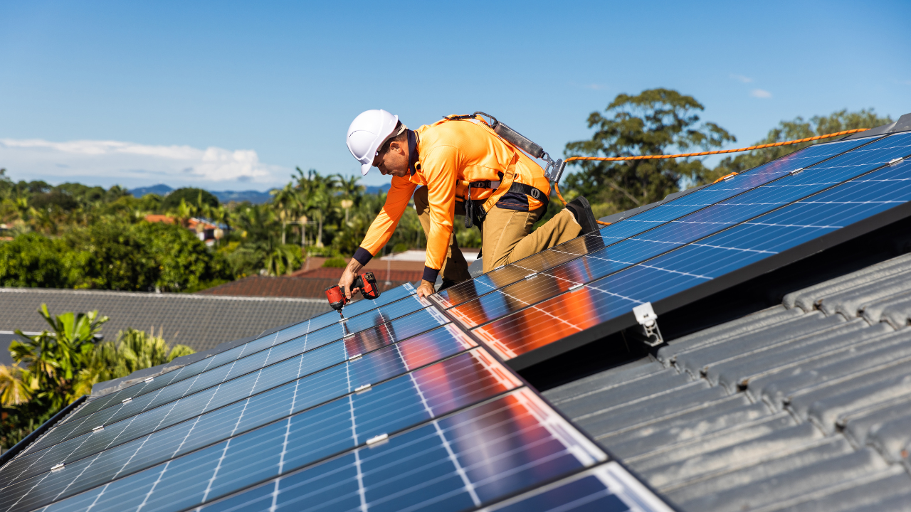 Técnico instalando paneles solares en un techo residencial